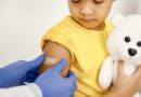 Doctor Stick A Band Aid On A Girl's Shoulder After A Vaccination